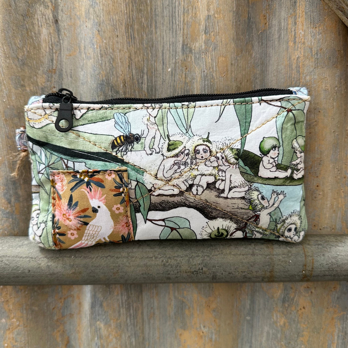 A rectangular zippered pouch with a whimsical woodland animal print,